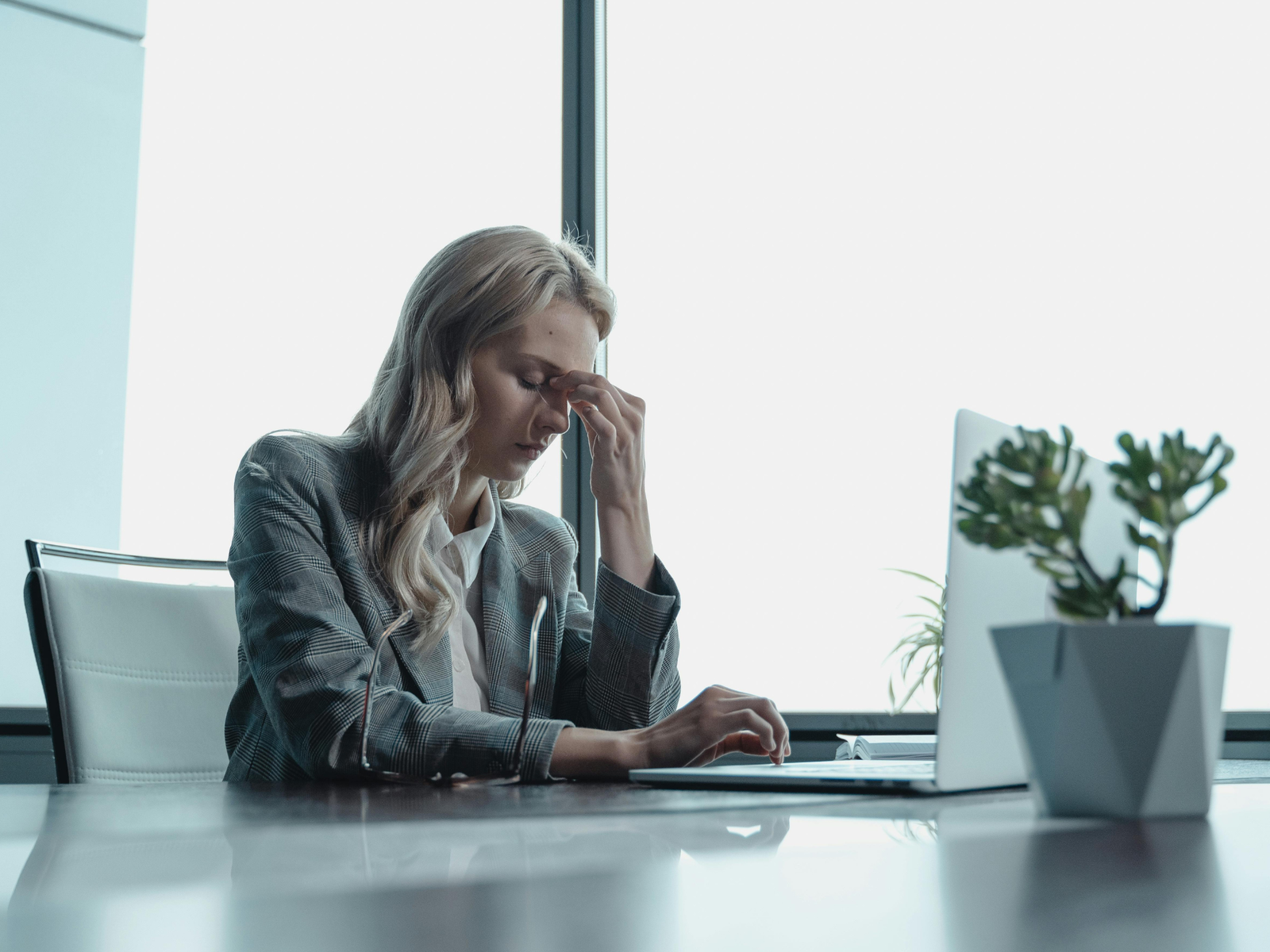 Femme fatiguée devant un écran d'ordinateur en fin de journée